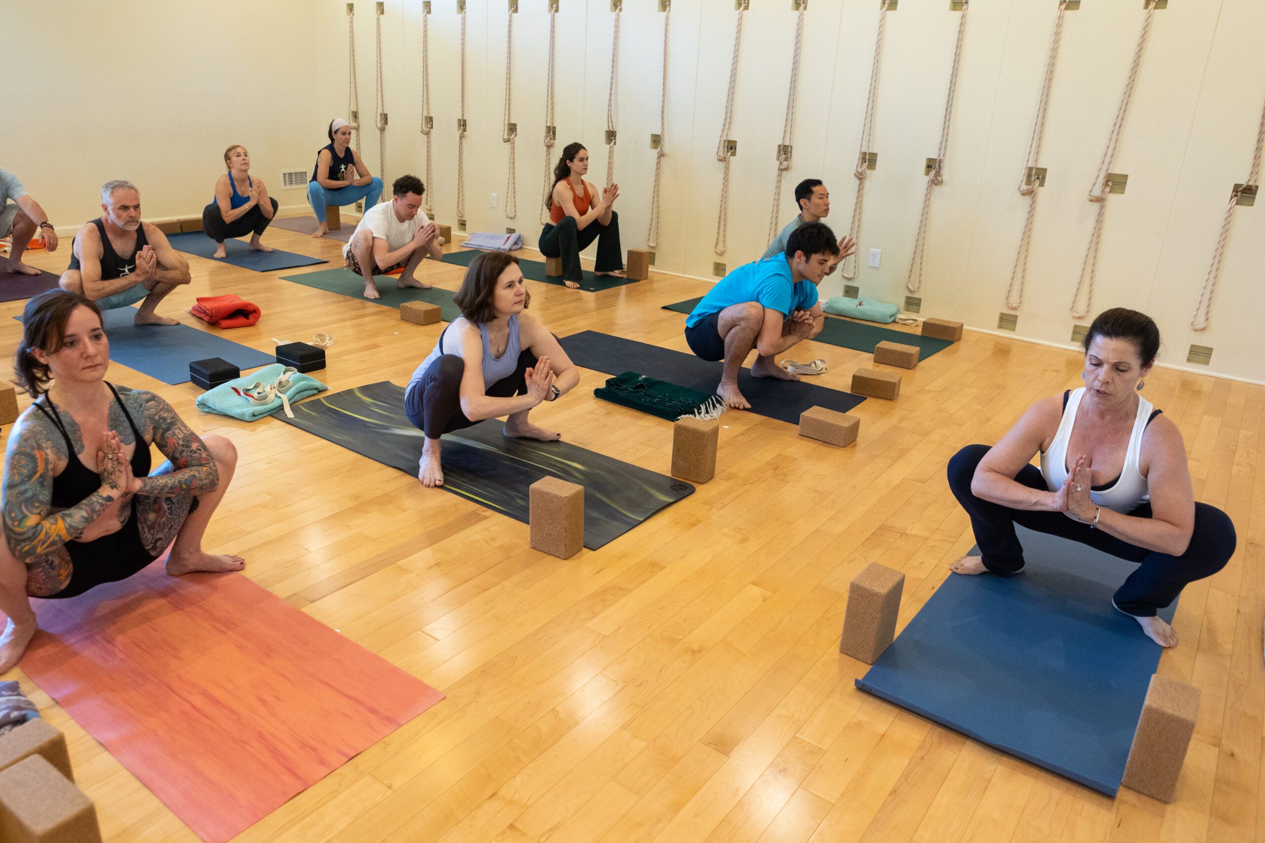 yoga class in malasana squat pose