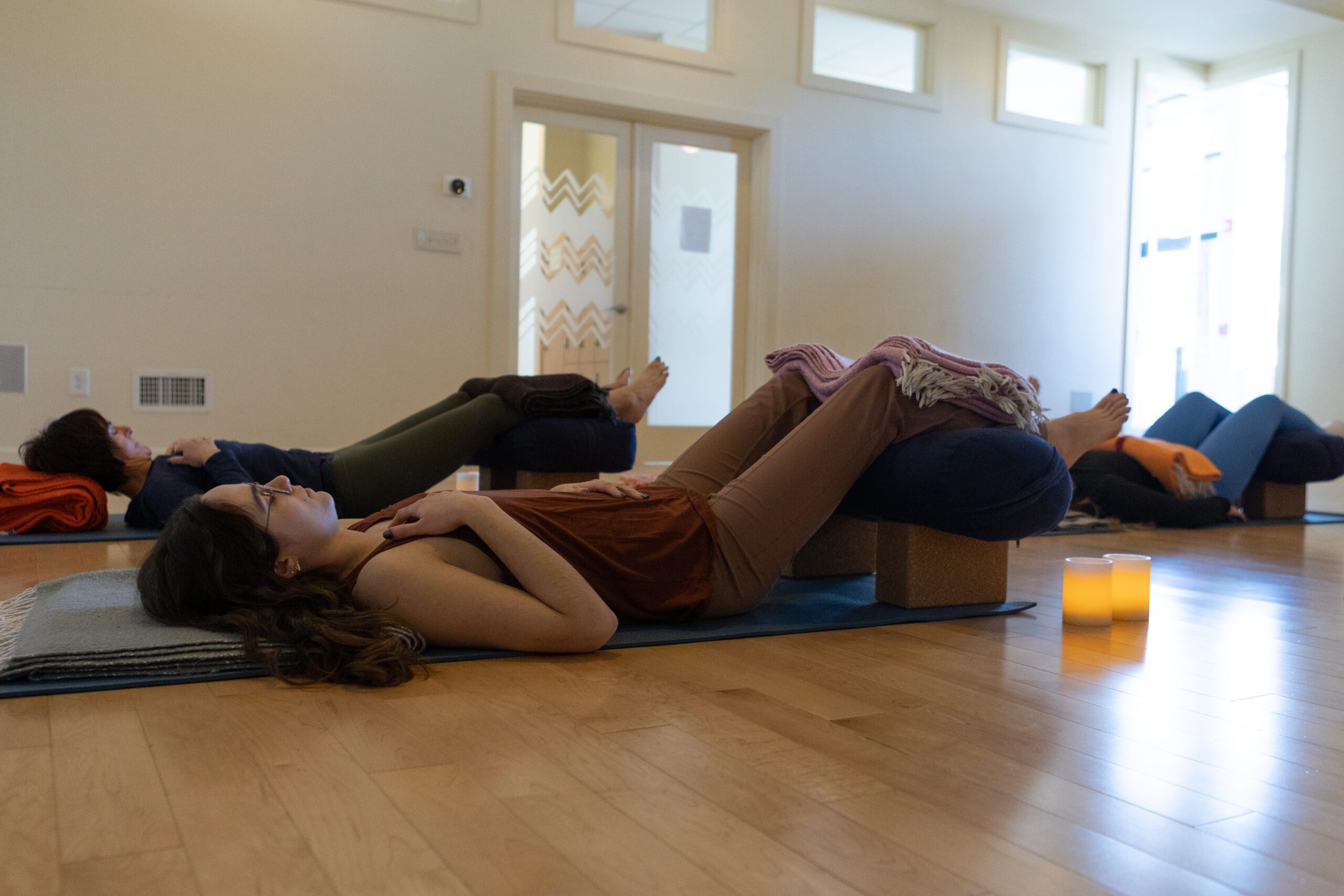 Women in stonehenge restorative yoga pose
